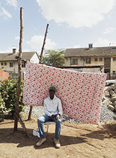 Man sits in front of flowered background in Nairobi, Kenya