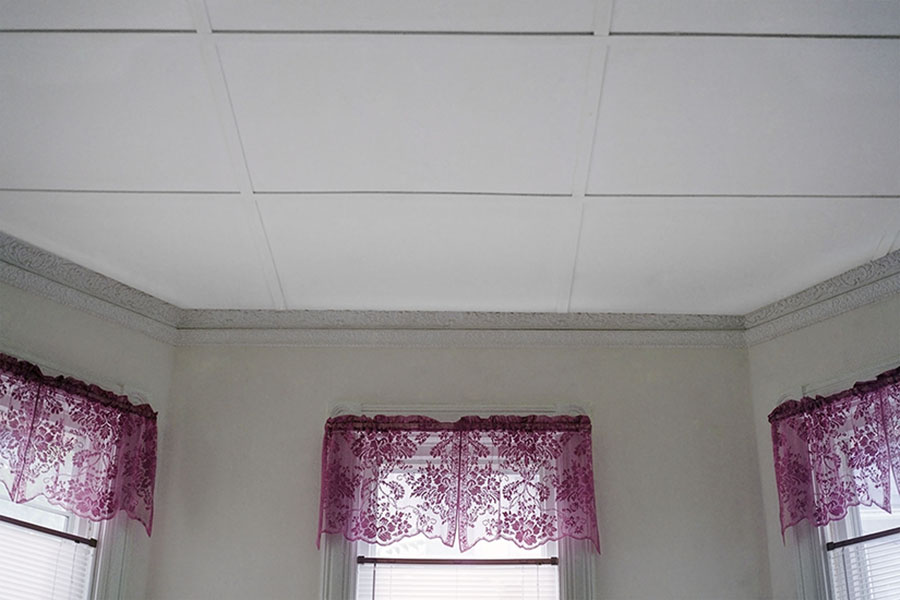 Digital Chromogenic Print. Color photograph, home interior, white ceiling tiles, octogon room, three windows, pink curtains, flower pattern
